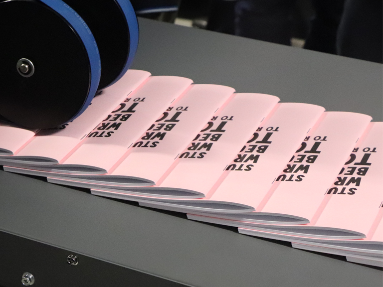 Long run pink booklet on conveyor